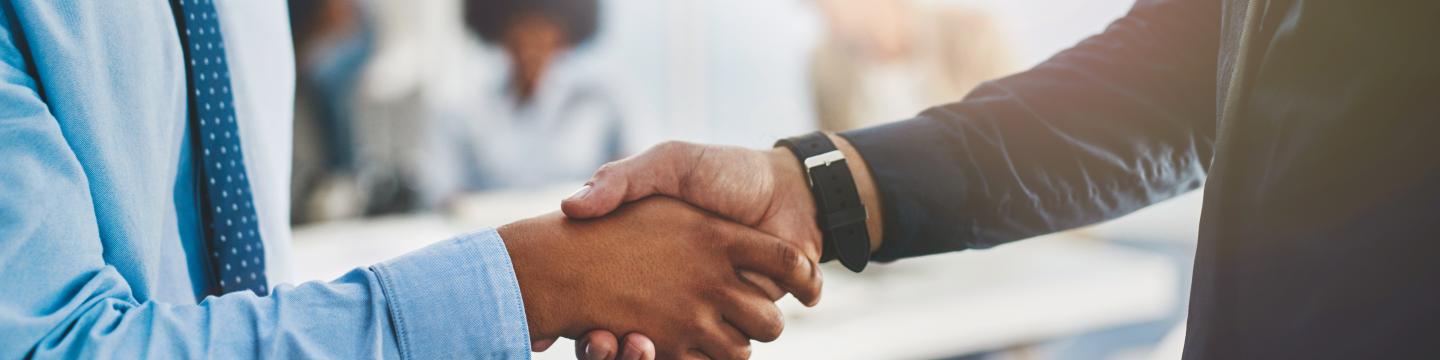 Mortgage broker and client shake hands.